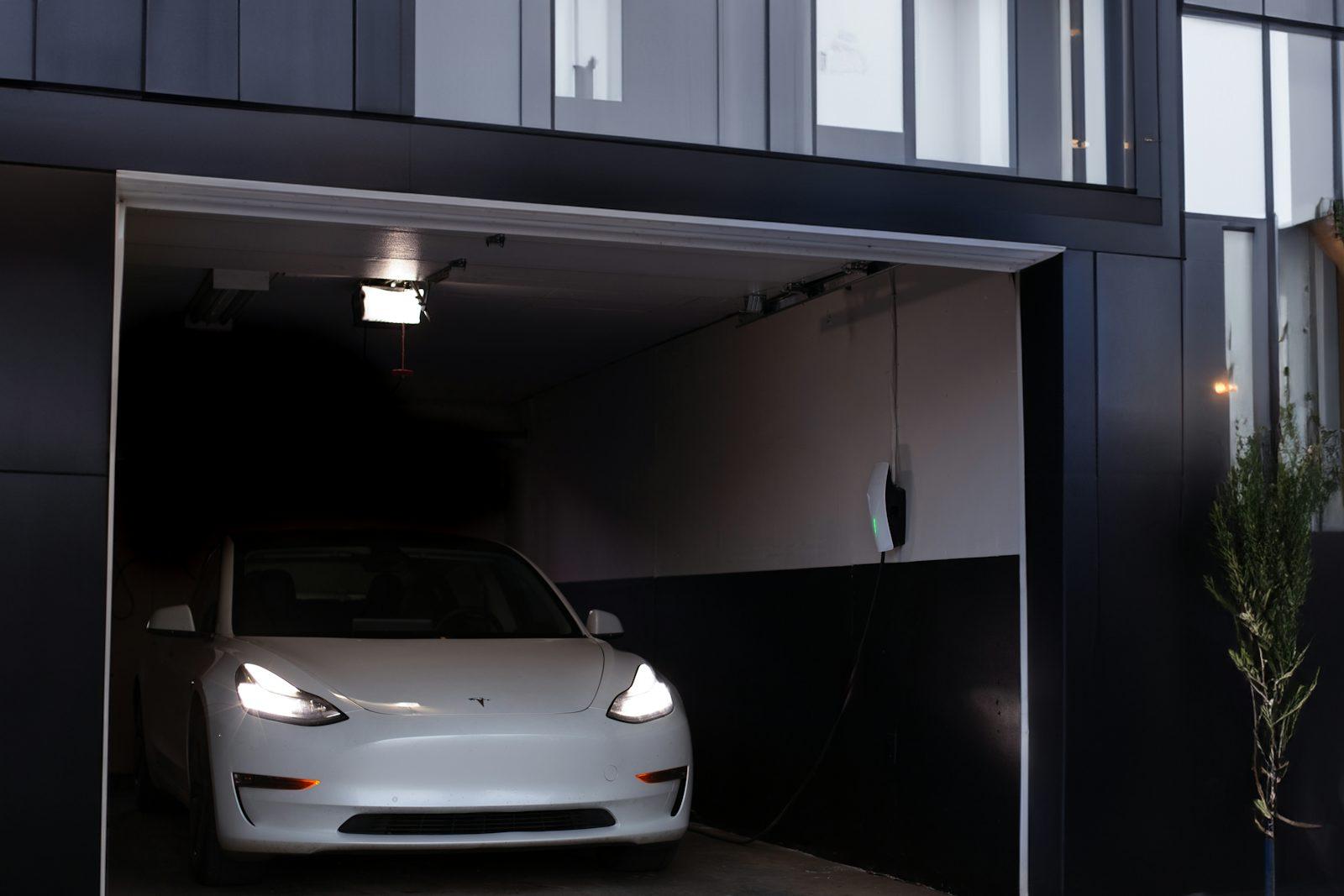 Carro branco carregando em garagem residencial com wallbox